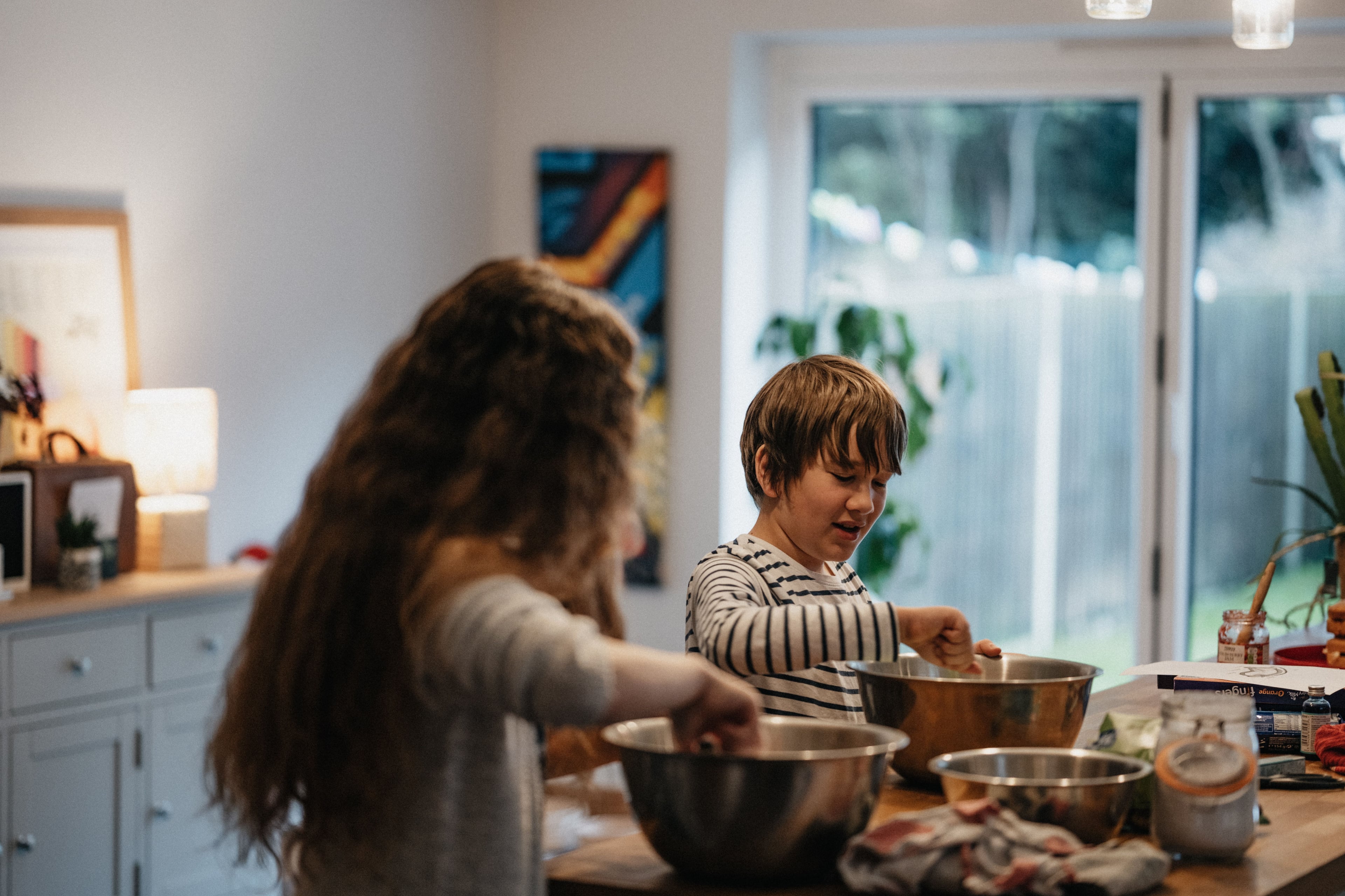 two children in a kitchen preparing a dish