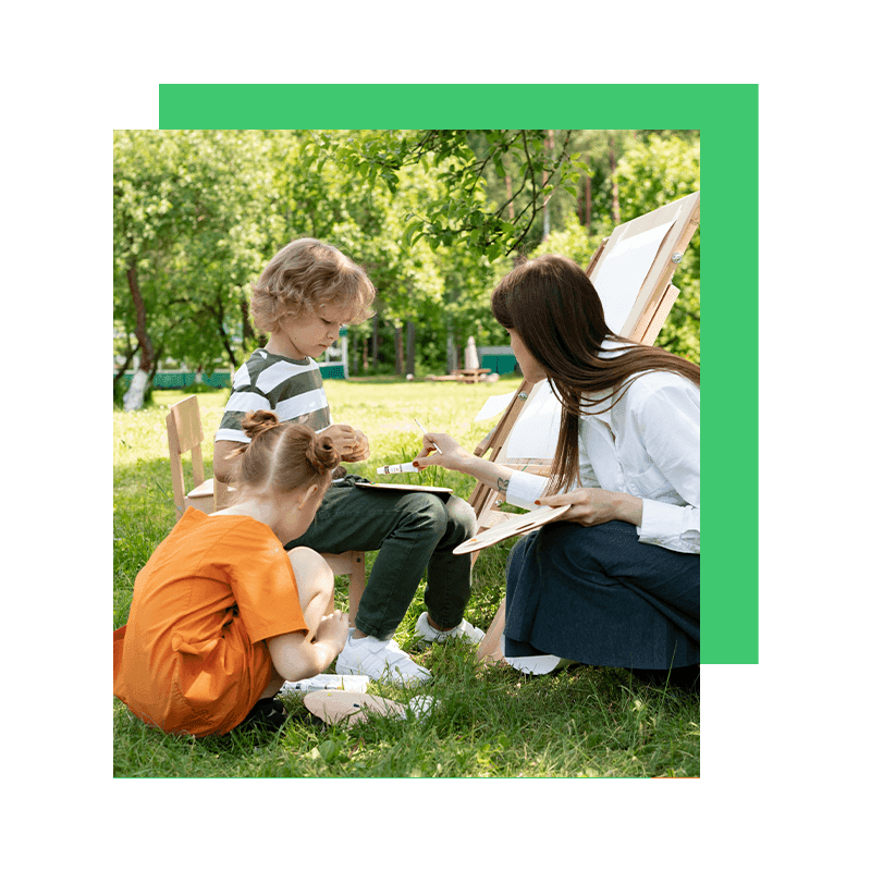 two kids and their mom doing art at the park