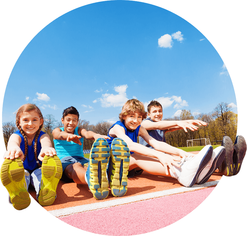 Portrait of four happy teenage kids sitting in a row doing stretching exercises outdoors on the stadium
