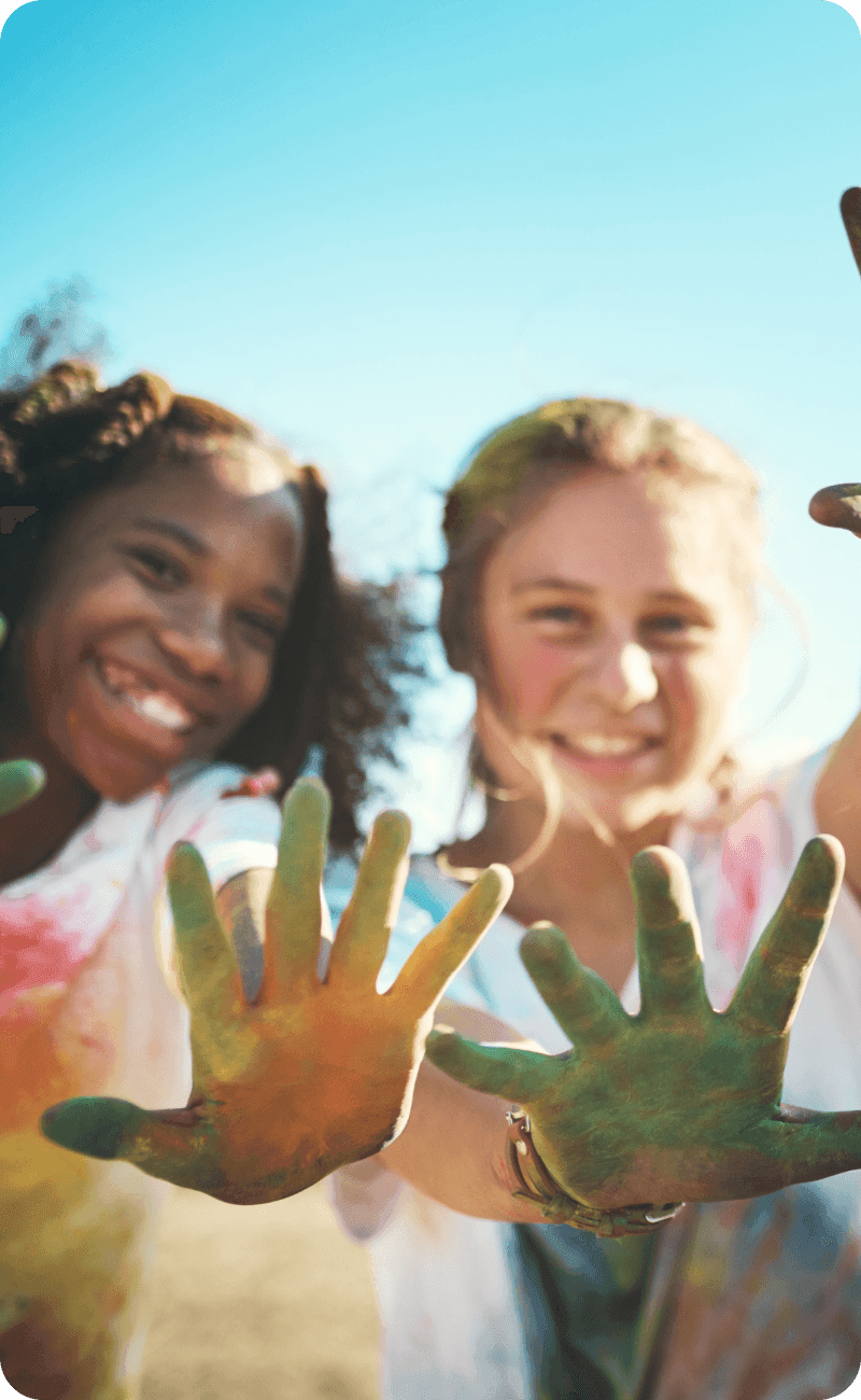 Shot of a group of teenagers having fun with colourful powder at summer camp