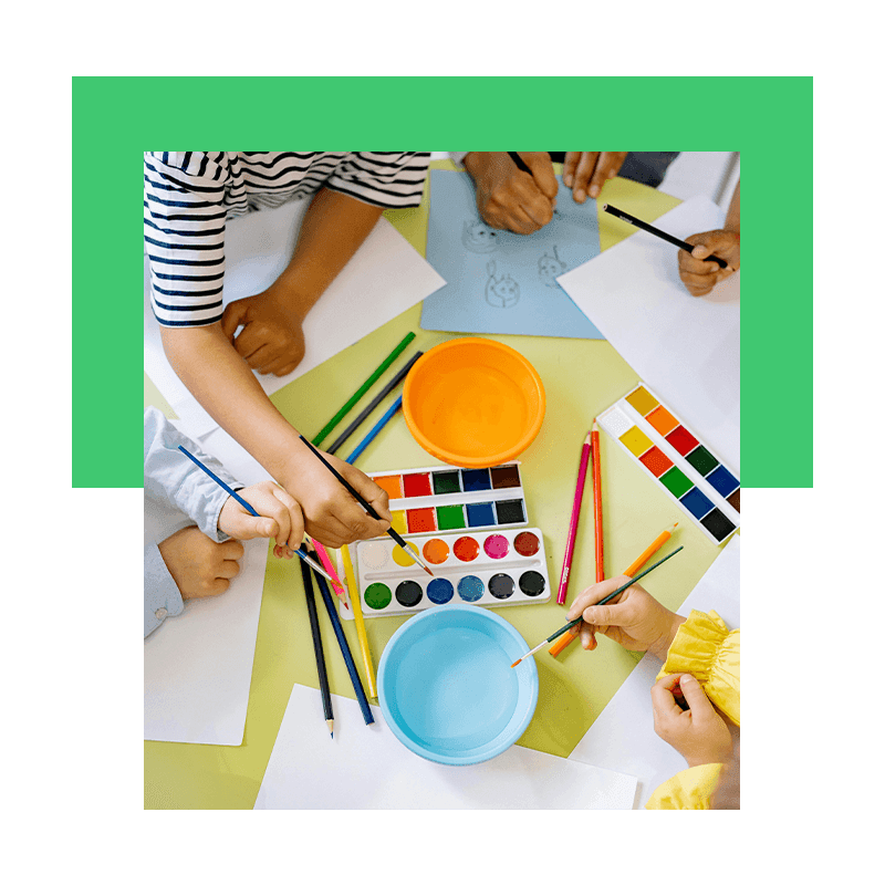 kids using watercolor and brushes to do art
